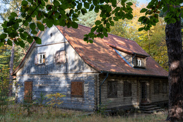 Old wooden house hidden in the forest – editorial use only