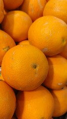 Close up pile of tasty fresh oranges sold at the market as a background.