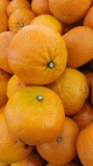 Close up pile of tasty fresh oranges sold at the market as a background.