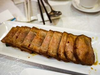 close up of Chinese spicy soy sauce marinated slices of beef ox tongue on a white plate