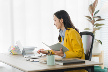 Focused Professional: A focused individual, dressed in a vibrant yellow blazer, works diligently at...