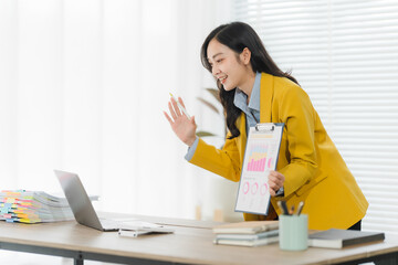 Professional in a video conference: A professional woman engages in a virtual meeting with her...