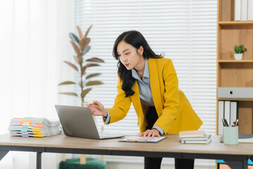 Focused Professional Woman Working on Laptop: A dynamic image of a professional woman in a yellow...