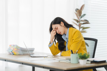 Burnout's Burden: A stressed professional, draped in a vivid yellow blazer, finds herself wrestling...