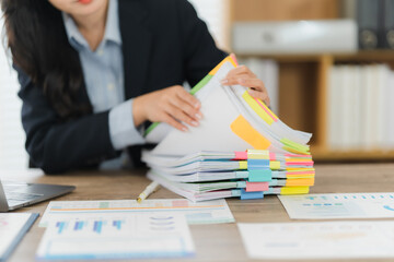 Focused Workflow: A diligent individual navigates a sea of paperwork, meticulously organizing a...