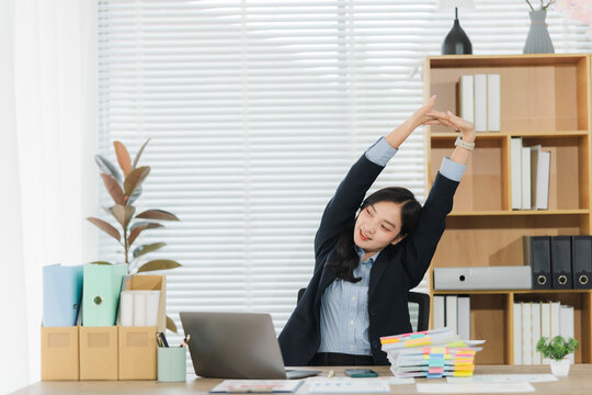 Workplace Stretch: An individual stretches at desk, embracing wellness, focus, and a sense of relief. A tranquil scene of mindful relaxation, a perfect moment to rejuvenate the mind and body.