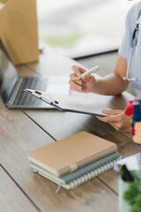 Doctor Writing Notes: A close-up shot of a doctor's hands meticulously writing notes on a...