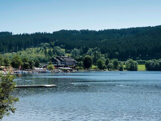 Die Seestraße in Titisee-Neustadt, die Flanier- und Einkaufsstraße mit einem Blick auf den Titisee und  den Anlegestellen der Schifffahrtsgesellschaften  für Ausflug auf dem See 