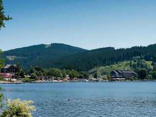  Die Seestraße im Zentrum von Titisee-Neustadt, seine Geschäfte, die Seite und der Seesteg am Fuße des Winterwaldes, der Glasberg und das Saiger Kreuz am nordöstlichen Horizont
