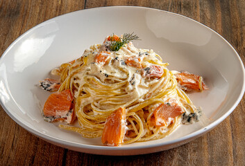 Creamy spaghetti with gorgonzola cheese and smoked salmon, a rich and elegant fusion of flavors finished with a touch of freshness.