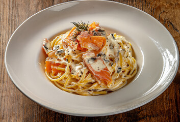 Creamy spaghetti with gorgonzola cheese and smoked salmon, a rich and elegant fusion of flavors finished with a touch of freshness.
