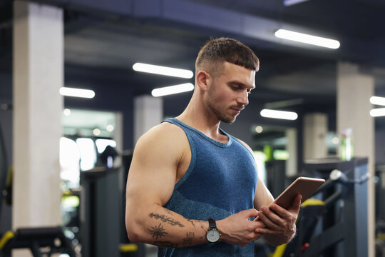 Personal trainer with tablet in sport center - Powered by Adobe