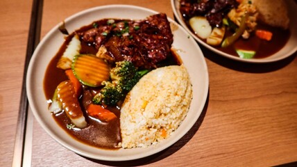 close up of Japanese Pork Cartilage curry with rice, served with vegetables, including broccoli, carrots, and zucchini on a wooden table