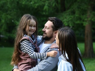 Naklejka premium Happy parents and their daughter in park
