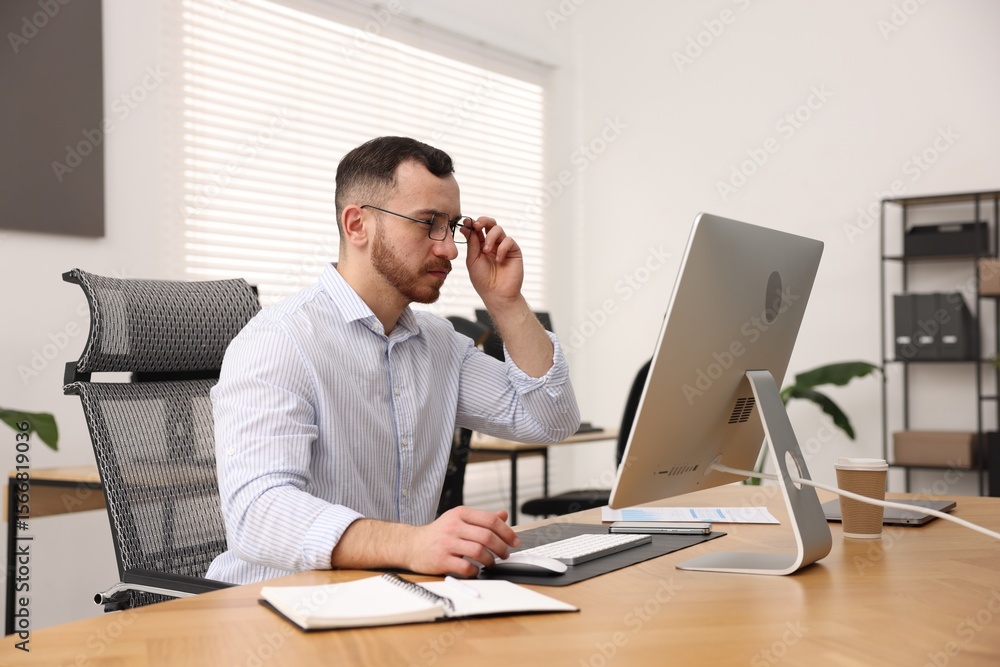 Poster man working on computer at desk in office