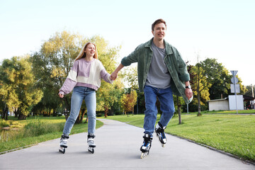 Happy couple roller skating together in park