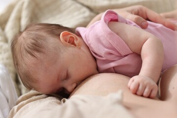 Mother breastfeeding her newborn baby indoors, above view