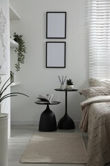 Comfortable bed with beautiful linens, nesting tables and decor in bedroom