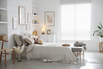 Comfortable bed with soft linens in room. Home textile