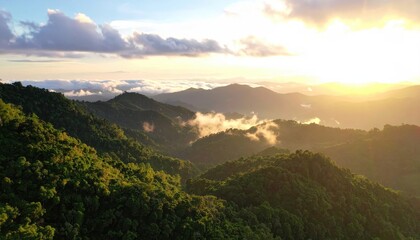 Obraz premium Lush green mountains at sunset, with clouds and golden light