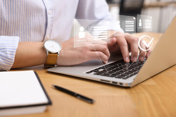 Human resources manager working on laptop at table, closeup. Virtual check mark and resumes over...
