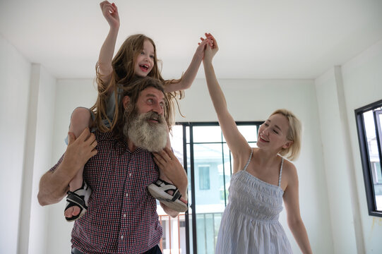 American family with father, mother and young daughter enjoy moving in new house in real estate project