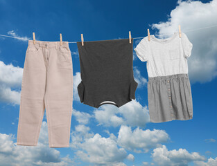 Different clothes drying on washing line against blue sky