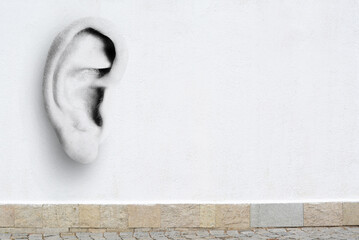 Human ear in white concrete wall, space for text. Eavesdropping, concept that even walls have ears