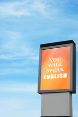 You Will Speak English text on advertising board against blue sky. Language course