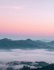 Fototapeta premium Mountain peaks emerging through a sea of clouds, pink sky