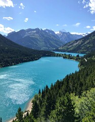 Stunning turquoise lake between verdant forest and imposing mountains