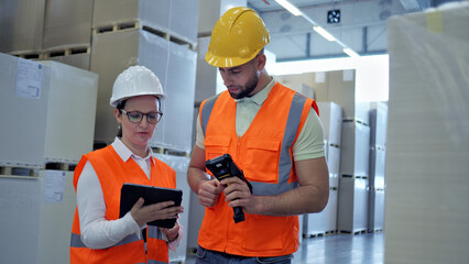 In a busy cargo warehouse, two industrial operators work together—one with a tablet, the other with a barcode scanner—demonstrating precision and efficiency in global supply chain logistics.