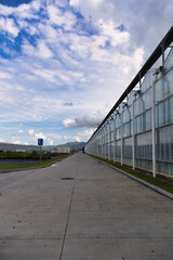Obraz premium Modern Greenhouse Facility Under a Cloudy Sky