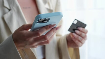 businesswoman with a mobile phone and a bank card makes online purchases.
Payment for goods online.
Using a bank card.
Transfer money online.
Pay for services using a bank card - Powered by Adobe