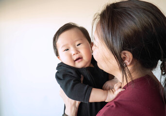 A woman is holding a baby in her arms