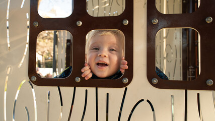 A young child is looking out of a window