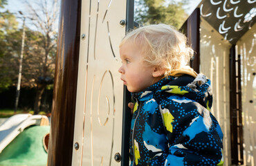 A small child on a playground in a park.