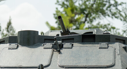 Close-up of  turret with mounted machine gun, hatches, and protective armor elements.