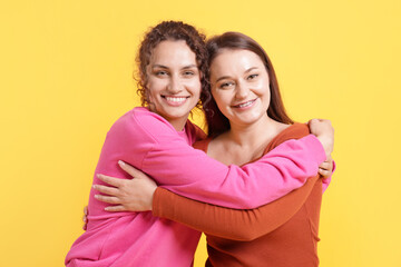 Friends hugging each other on orange background
