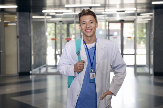 Medical student in uniform with backpack indoors