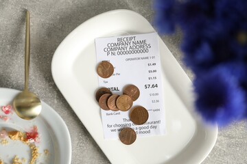 Tips, receipt and dirty plate on grey table, flat lay