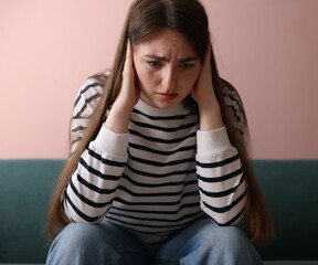 Woman suffering from paranoia on sofa at home