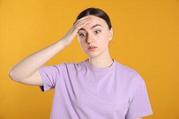 Portrait of confused woman on orange background