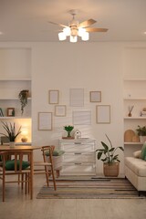 Stylish dining table with chairs and comfortable sofa in room. Interior design