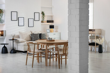 Table, chairs and comfortable sofa indoors. Interior design