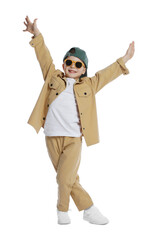Happy little boy in sunglasses and baseball hat dancing on white background
