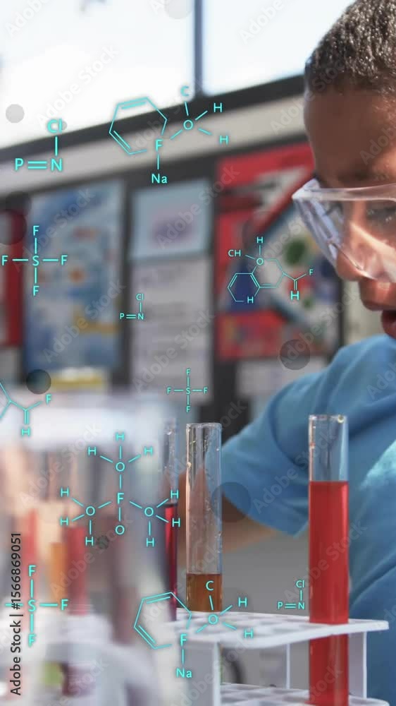 Poster chemical formulas and molecular structures over boy conducting science experiment in lab