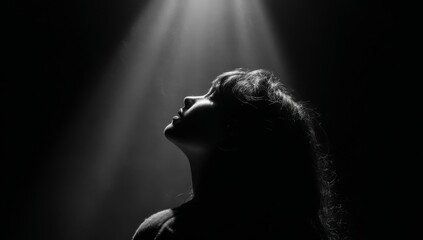 Silhouette of a Woman Gazing Upward in Dramatic Lighting