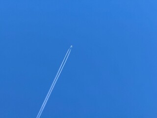 The plane flies into the blue sky.
