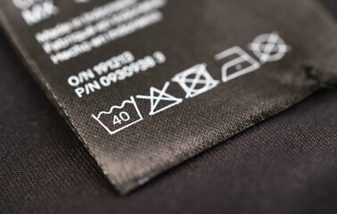 Care instructions displayed on fabric label for clothing maintenance. Wash at 40 degrees.
